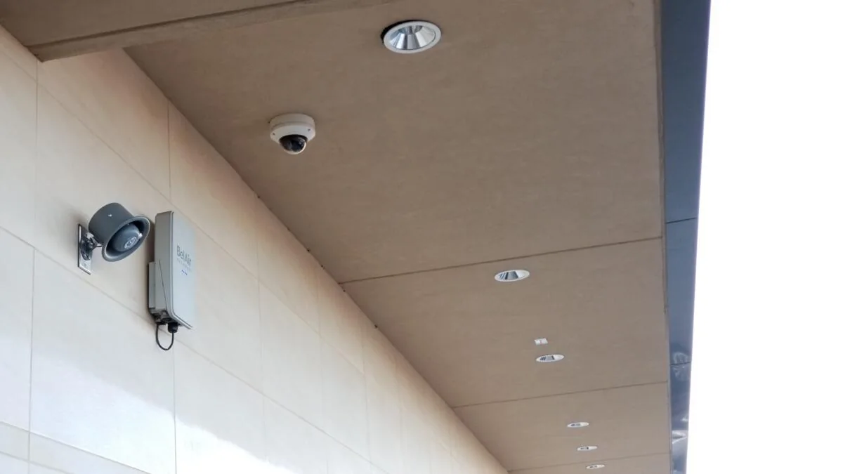 Dome and bullet cameras beneath a building canopy